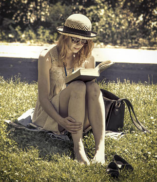 Girl sitting on the grass reading a book